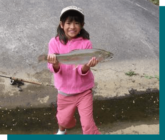 A young girl holding a fish in her hands.